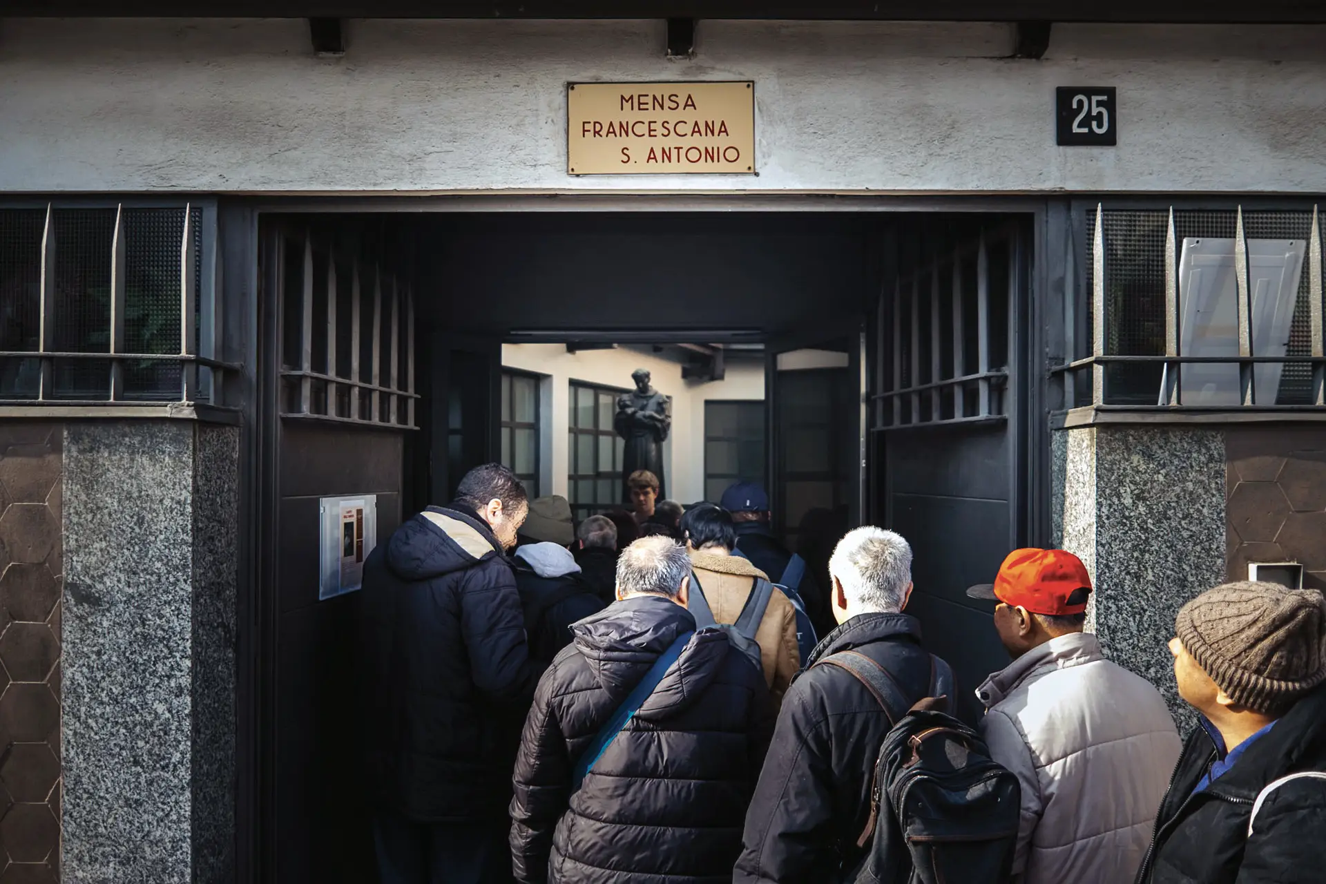 Persone in fila che stanno entrando nella mensa Francescana Sant'Antonio