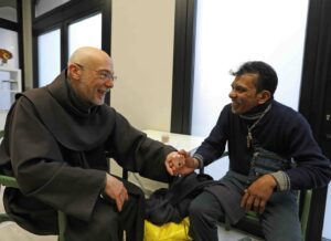 Frate che ascolta un ospite tenendolo per mano